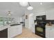 Well-appointed kitchen with black appliances, ample counter space, and a seamless flow to the living area at 4995 County Road 121D, Wildwood, FL 34785