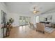 Spacious living room with tiled floors, ceiling fan, neutral furniture, and views of the backyard through French doors at 4995 County Road 121D, Wildwood, FL 34785