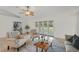 Bright living room featuring neutral furniture, tiled floors, a ceiling fan, and a cozy seating arrangement at 4995 County Road 121D, Wildwood, FL 34785