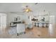 Open-concept living room with tiled flooring, neutral furniture, and views into the kitchen and backyard at 4995 County Road 121D, Wildwood, FL 34785