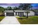 Updated single-story home with modern gray garage door, and a manicured lawn at 1309 Buccaneer Ave, Deltona, FL 32725