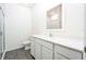 Modern bathroom with white cabinets, quartz countertop, walk-in shower, and gray wood-look floors at 13481 Leaping Water Way, Astatula, FL 34705