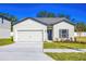 Charming single-story home featuring a two-car garage, well-manicured lawn, and welcoming front entrance at 13481 Leaping Water Way, Astatula, FL 34705