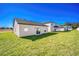 Backyard view of a single-story house, with a grassy lawn and neighboring houses visible at 13481 Leaping Water Way, Astatula, FL 34705