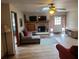 Cozy living room featuring a brick fireplace, comfy sectional sofa, and wood-look flooring at 2468 Fawn Run, Oviedo, FL 32765