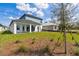 Spacious backyard showcasing a well-manicured lawn, mulch beds, and a covered patio for outdoor relaxation at 6074 Sacred Oak Ave, Mount Dora, FL 32757