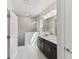 Bathroom featuring a double vanity, large mirror, and shower with a tile surround at 6074 Sacred Oak Ave, Mount Dora, FL 32757