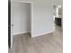Bedroom featuring neutral paint and light wood flooring with a view into bathroom at 6074 Sacred Oak Ave, Mount Dora, FL 32757