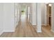 Bright hallway with light wood floors, white walls, and multiple doors creating a modern, clean aesthetic at 6074 Sacred Oak Ave, Mount Dora, FL 32757