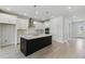 Contemporary kitchen with a central island, white cabinetry, and stainless steel appliances for a sleek design at 6074 Sacred Oak Ave, Mount Dora, FL 32757