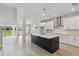 Modern kitchen featuring a large center island, white cabinets, stainless steel appliances, and open layout at 6074 Sacred Oak Ave, Mount Dora, FL 32757