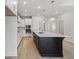 Well-lit kitchen with a center island, white cabinets, and stainless steel appliances offering a modern aesthetic at 6074 Sacred Oak Ave, Mount Dora, FL 32757