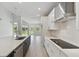 Modern kitchen with white cabinets, stainless steel appliances, and a large center island at 6074 Sacred Oak Ave, Mount Dora, FL 32757