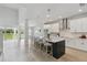 Modern kitchen features white cabinets, stainless steel appliances, and an island with bar seating at 6074 Sacred Oak Ave, Mount Dora, FL 32757