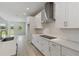 Kitchen featuring white cabinets, stainless steel hood, and modern appliances at 6074 Sacred Oak Ave, Mount Dora, FL 32757