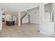 Open living space with light hardwood floors leading to modern kitchen and staircase at 6074 Sacred Oak Ave, Mount Dora, FL 32757