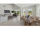 Open-concept living and dining area with natural light, modern decor, and wood-style flooring at 6074 Sacred Oak Ave, Mount Dora, FL 32757