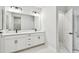 Double vanity bathroom with modern fixtures and white cabinets at 5938 Bristle Oak St, Mount Dora, FL 32757