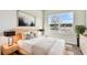 Light and airy bedroom with a large window, modern decor, and wood furnishings at 5938 Bristle Oak St, Mount Dora, FL 32757