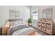 Charming bedroom with a comfy bed, a large window, and storage shelves with baskets at 5938 Bristle Oak St, Mount Dora, FL 32757