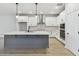 Modern kitchen with gray island and white cabinets at 5938 Bristle Oak St, Mount Dora, FL 32757