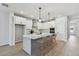 Bright modern kitchen featuring white cabinets, a stylish island, and stainless steel appliances at 5938 Bristle Oak St, Mount Dora, FL 32757
