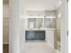 Bright bathroom featuring double vanity, walk-in shower with glass enclosure, and light gray tile flooring at 6063 Sacred Oak Ave, Mount Dora, FL 32757
