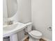 Elegant powder room with a pedestal sink, sleek fixtures, and stylish wood-look flooring at 6063 Sacred Oak Ave, Mount Dora, FL 32757