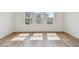 Bright bedroom with sunlit wood floors and three large windows at 6063 Sacred Oak Ave, Mount Dora, FL 32757
