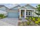 Charming single-story home with a well-manicured lawn and a stylish blue exterior and yellow door at 6063 Sacred Oak Ave, Mount Dora, FL 32757