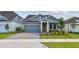 Beautiful single-story home featuring a well-kept lawn, gray brick driveway, and modern blue exterior at 6063 Sacred Oak Ave, Mount Dora, FL 32757