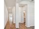 Bright hallway with wood floors, white walls, recessed lighting, and view of the bathroom and living spaces at 6063 Sacred Oak Ave, Mount Dora, FL 32757