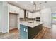 Bright kitchen featuring a large island with a sink, stainless steel appliances, and sleek white cabinetry at 6063 Sacred Oak Ave, Mount Dora, FL 32757