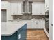 Beautiful kitchen featuring white cabinets, stainless steel appliances, gray backsplash, and large island with bar seating at 6063 Sacred Oak Ave, Mount Dora, FL 32757