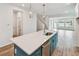 Bright, open kitchen boasts a quartz island, stylish pendants, and stainless steel appliances at 6063 Sacred Oak Ave, Mount Dora, FL 32757