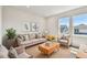 Cozy living room features neutral colors, comfortable seating, and natural light from large windows at 6063 Sacred Oak Ave, Mount Dora, FL 32757