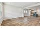 Spacious living area with sleek wood flooring, neutral walls, and views into the kitchen at 6063 Sacred Oak Ave, Mount Dora, FL 32757