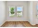 Bright and airy room with wood flooring, white walls, and large windows offering ample natural light at 6063 Sacred Oak Ave, Mount Dora, FL 32757