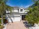Two-story house with white garage door, landscaping, and palm trees at 13438 Davenham Pt, Orlando, FL 32832