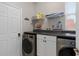 Laundry room with washer, dryer, and ample shelving at 13438 Davenham Pt, Orlando, FL 32832