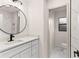 A bright bathroom featuring elegant marble tiling, a round mirror, and modern fixtures at 3203 S Polk Ave, Lakeland, FL 33803