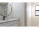 Elegant bathroom with marble tile, black faucet, a round mirror, and natural light at 3203 S Polk Ave, Lakeland, FL 33803