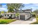 Charming two-story home features a spacious driveway, a gray garage door, and a well-manicured lawn at 3203 S Polk Ave, Lakeland, FL 33803