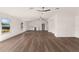 Open-concept living space with wood-look floors, bar with white cabinets, and vaulted ceilings at 3203 S Polk Ave, Lakeland, FL 33803