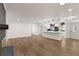 Open-concept living room with wood floors and modern kitchen with white cabinets at 3203 S Polk Ave, Lakeland, FL 33803
