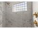 Tiled shower with glass block window and gold fixtures at 3203 S Polk Ave, Lakeland, FL 33803