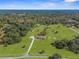 Aerial view showcasing a large estate with a long driveway, a house with a pool, and sprawling green pastures at 8631 Sw 70Th Ter, Bushnell, FL 33513