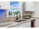 Modern kitchen with stainless steel sink, white cabinets, granite counters, and natural light at 8631 Sw 70Th Ter, Bushnell, FL 33513