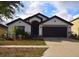 A single-story home with a manicured front lawn and an attached two-car garage at 1051 Woodlark Dr, Haines City, FL 33844