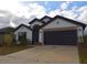Charming single-story home with a well-maintained lawn and a two-car garage at 1051 Woodlark Dr, Haines City, FL 33844